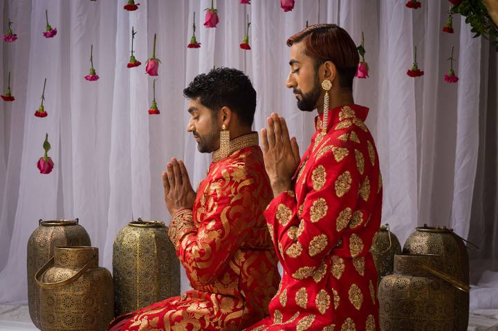 two men seen reflecting with their eyes closed and hands folded in a namaste