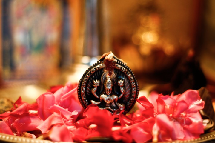 A copper idol of Goddess Lakshmi in midst of red flowers